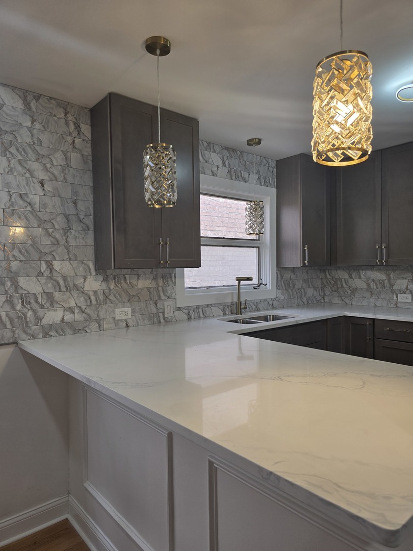 9727 South Michigan Avenue Chicago, IL 60628 - Photo 20 of 24 a view of a kitchen with a sink and a wooden floor