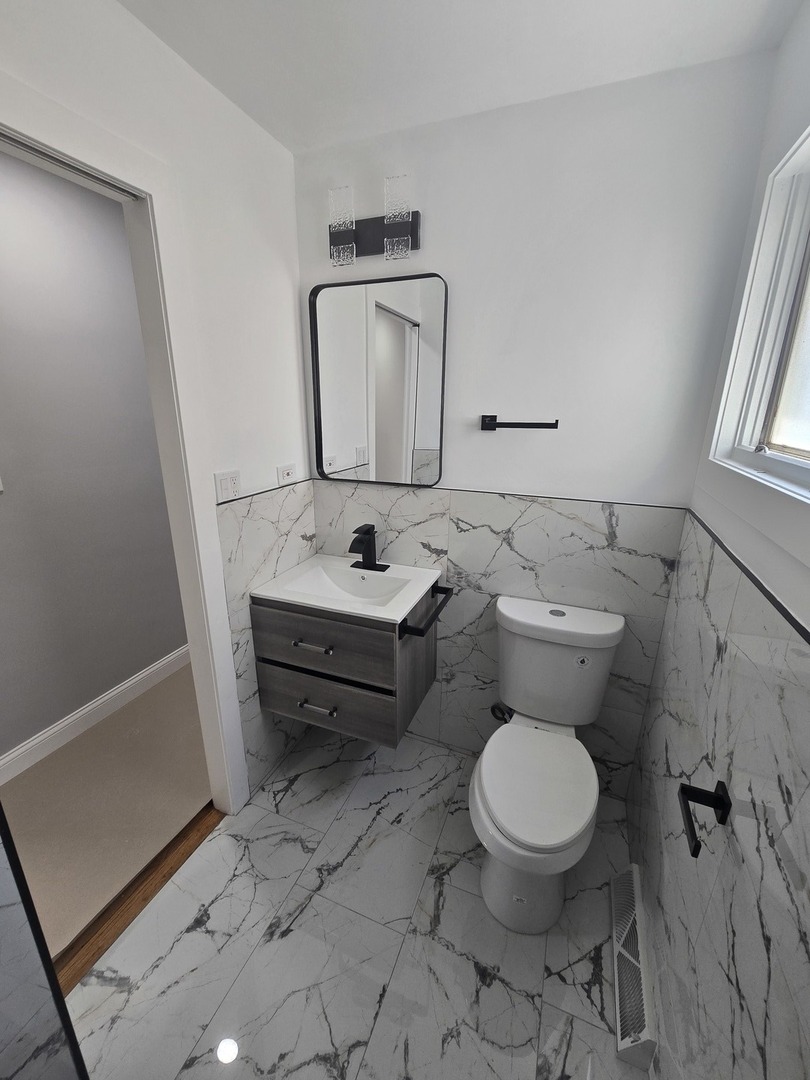 9727 South Michigan Avenue Chicago, IL 60628 - Photo 8 of 24 a bathroom with a toilet sink and mirror