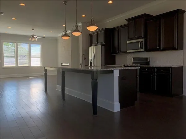 a kitchen with stainless steel appliances wooden floors wooden cabinets and sink