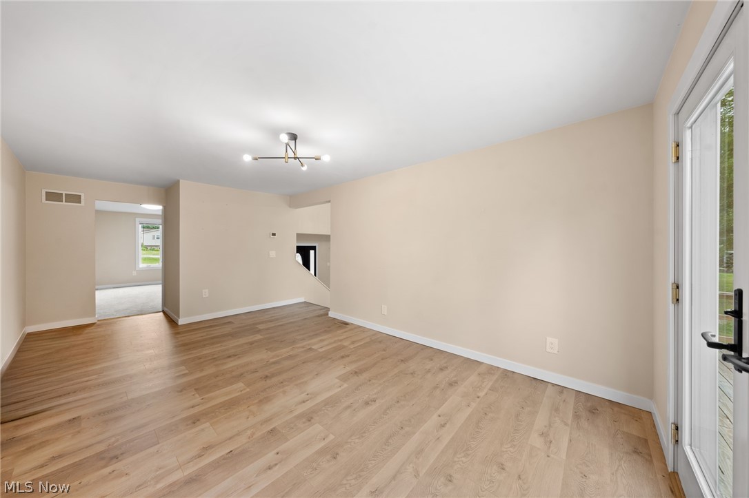 1617 Graham Road Stow, OH 44224 - Photo 24 of 49 Unfurnished living room with light hardwood / wood-style floors, a notable chandelier, and a wealth of natural light