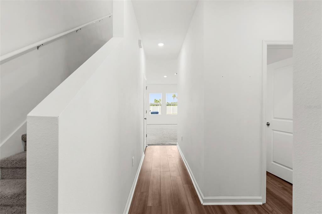 1038 Kelly Fern Loop Ruskin, FL 33570 - Photo 12 of 34 a view of a hallway with wooden floor and a bathroom