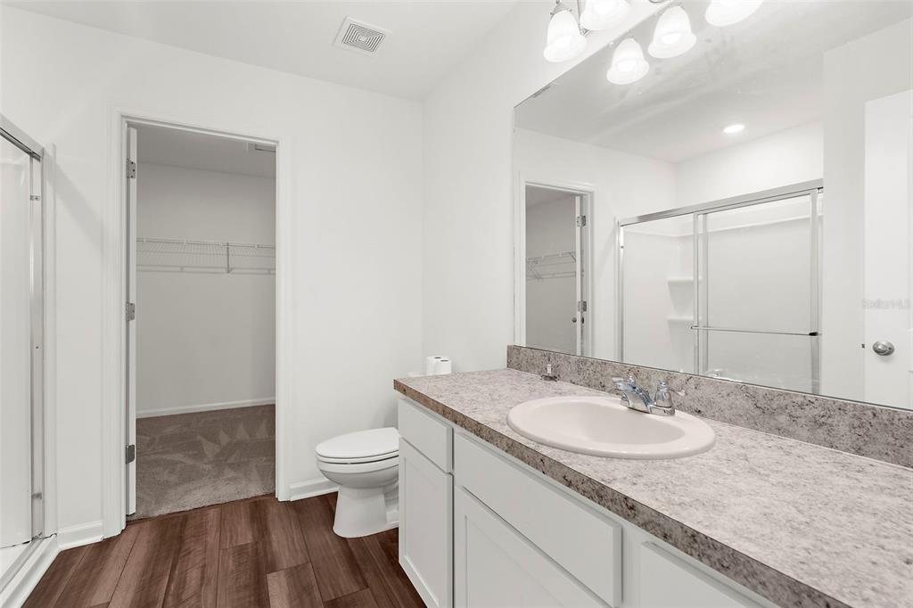 1038 Kelly Fern Loop Ruskin, FL 33570 - Photo 20 of 34 a bathroom with a granite countertop sink a toilet a shower and a mirror