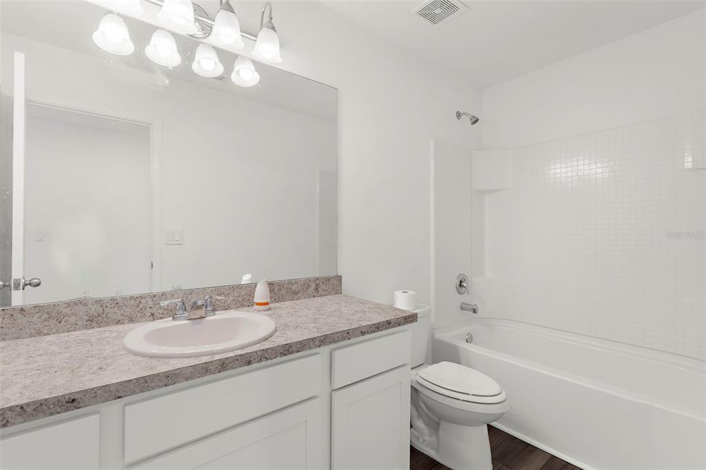 1038 Kelly Fern Loop Ruskin, FL 33570 - Photo 24 of 34 a bathroom with a sink a toilet and shower