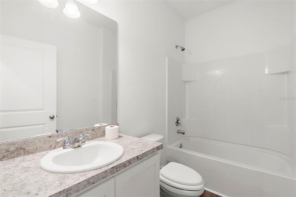 1038 Kelly Fern Loop Ruskin, FL 33570 - Photo 28 of 34 a bathroom with a granite countertop sink toilet and shower