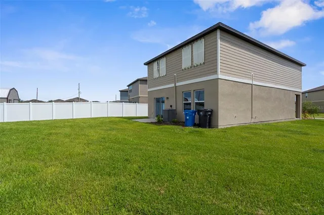 a view of a house with a big yard and large trees