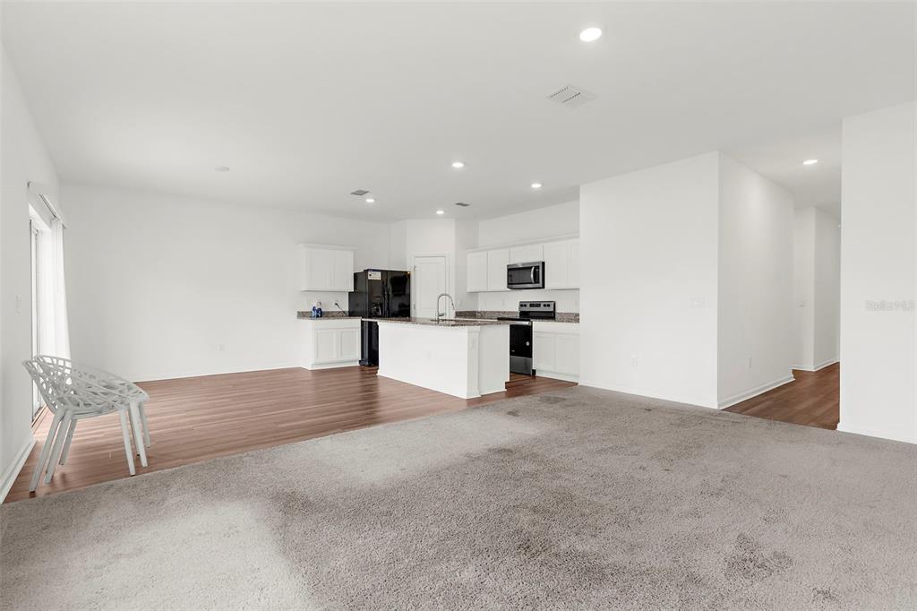 1038 Kelly Fern Loop Ruskin, FL 33570 - Photo 5 of 34 a view of kitchen with refrigerator and white cabinets