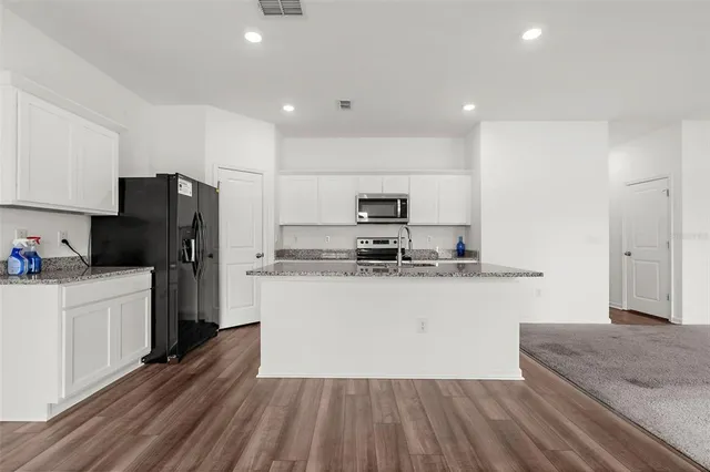 a kitchen with stainless steel appliances a refrigerator sink and microwave