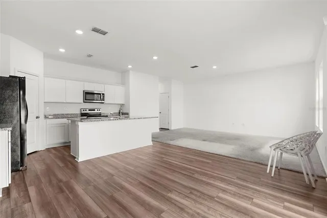 a kitchen with granite countertop white cabinets and stainless steel appliances