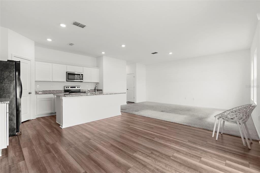 1038 Kelly Fern Loop Ruskin, FL 33570 - Photo 9 of 34 a kitchen with granite countertop white cabinets and stainless steel appliances