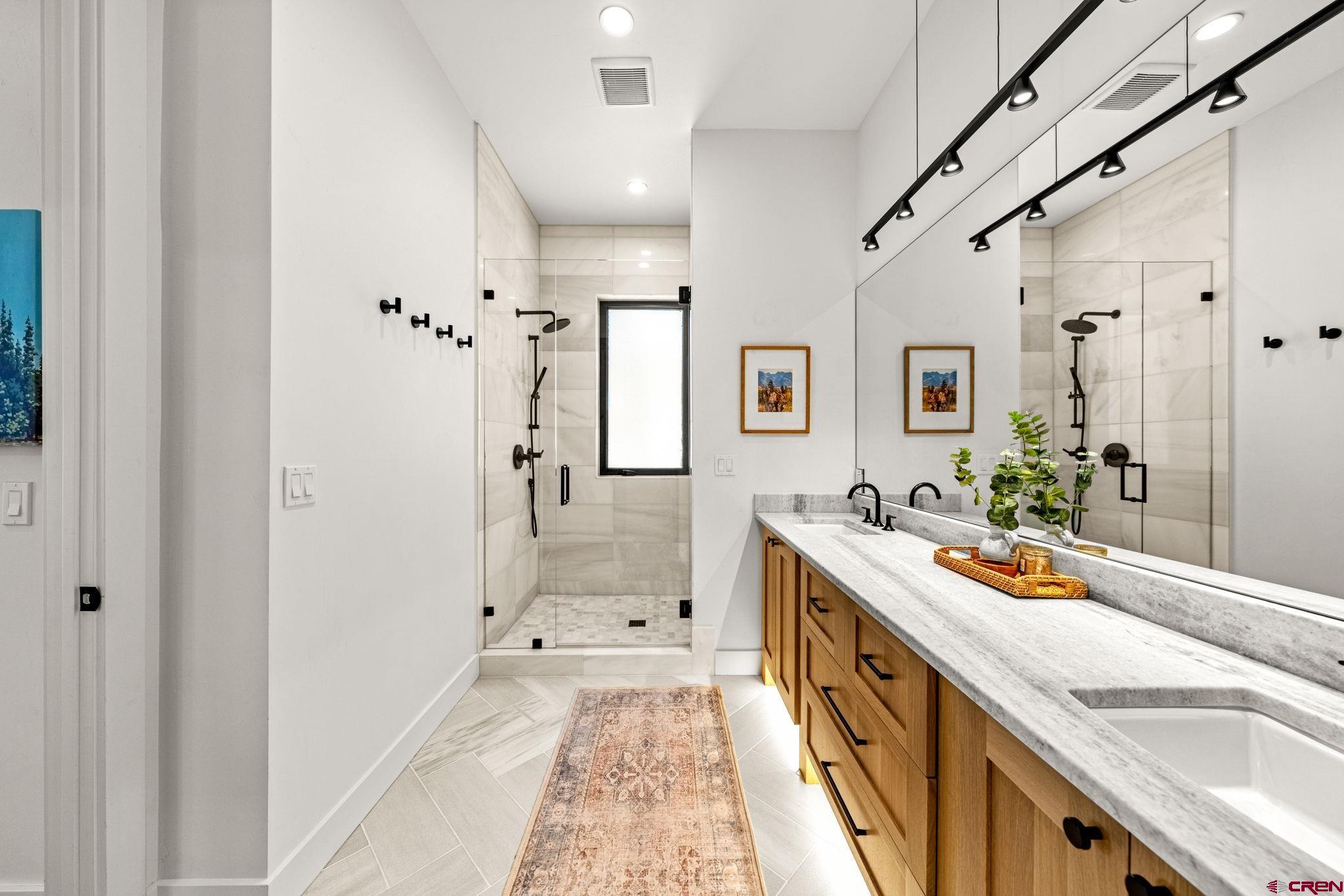 26 Boulder View Drive Durango, CO 81301 - Photo 27 of 45 a bathroom with a sink a large mirror and a shower