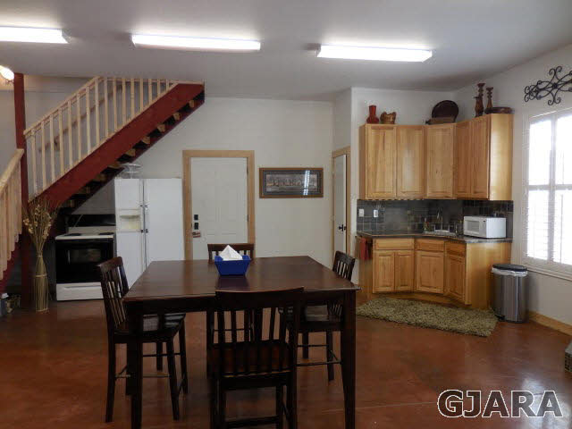 3581 G Road Palisade, CO 81526 - Photo 24 of 41 a kitchen with granite countertop a table chairs stove and cabinets