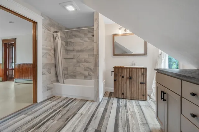a bathroom with a bathtub vanity and a shower