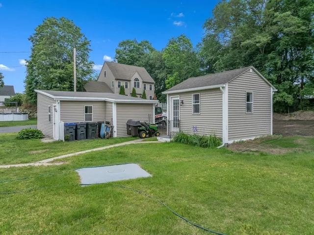 a front view of a house with a yard and trees
