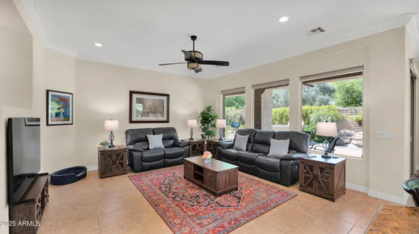 a living room with furniture a flat screen tv and kitchen view