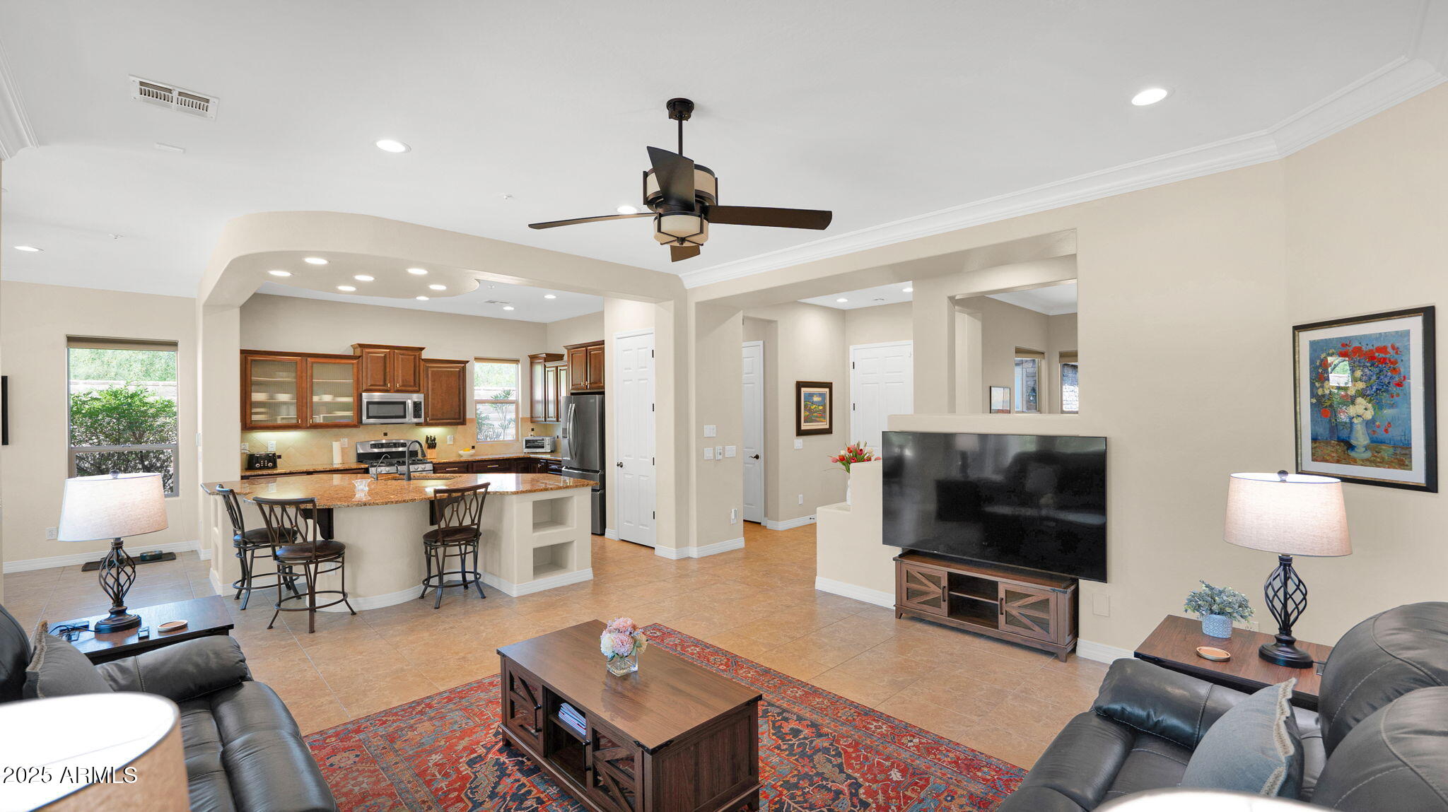 12981 West Yellow Bird Lane Peoria, AZ 85383 - Photo 22 of 47 a living room with furniture a flat screen tv and kitchen view