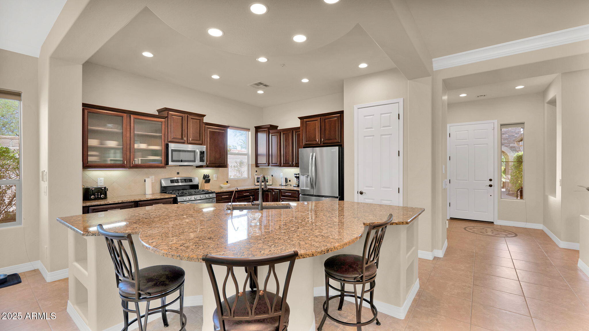 12981 West Yellow Bird Lane Peoria, AZ 85383 - Photo 23 of 47 a large kitchen with kitchen island a table and chairs in it
