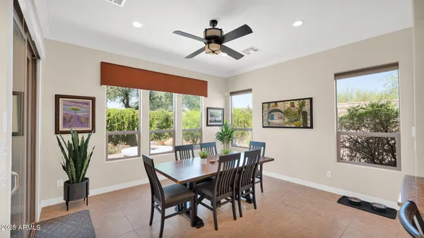 a dining room with furniture a floor to ceiling window and a potted plant