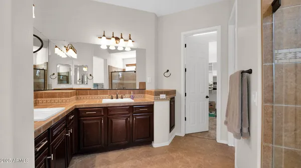 a spacious bathroom with a granite countertop sink mirror and a bathtub with shower