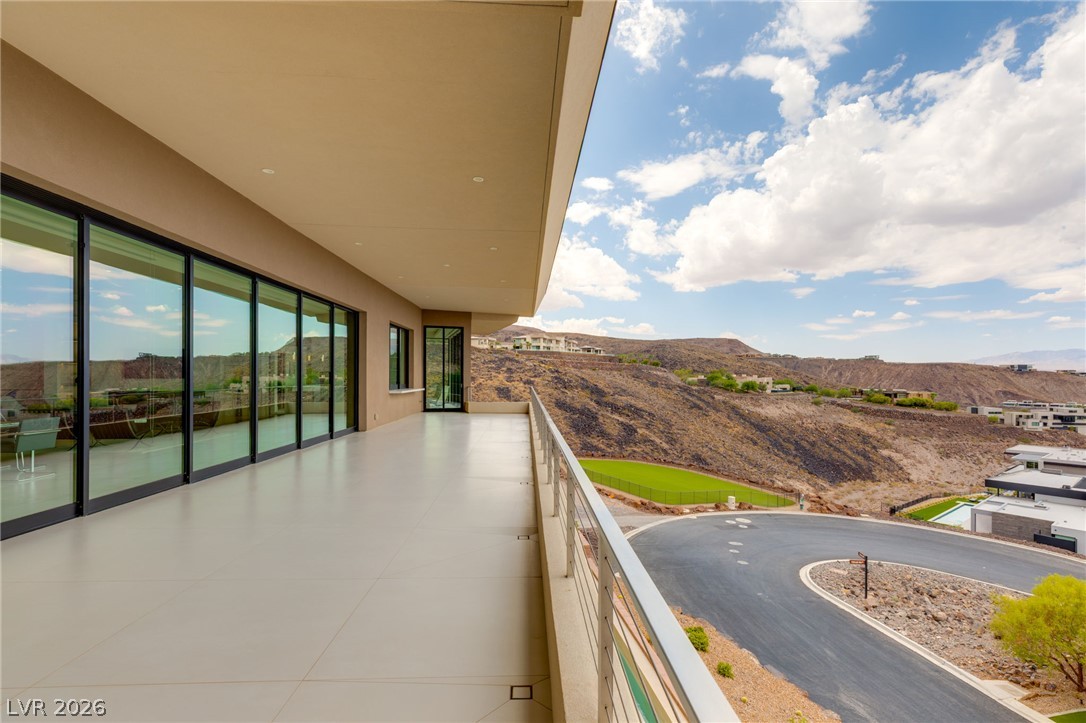 677 Overlook Rim Drive Henderson, NV 89012 - Photo 60 of 97 An upper-level balcony features tiled flooring, recessed lighting, and expansive sliding glass doors opening to mountain views.
