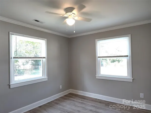 a view of a workspace with wooden floor and a window
