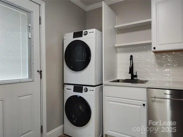 a utility room with sink dryer and washer