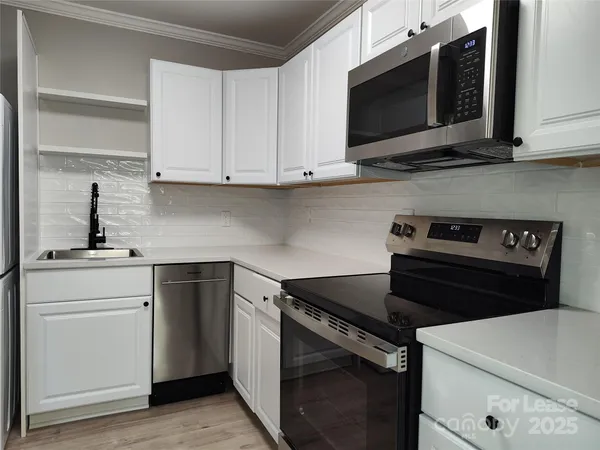 a kitchen with cabinets appliances and a sink