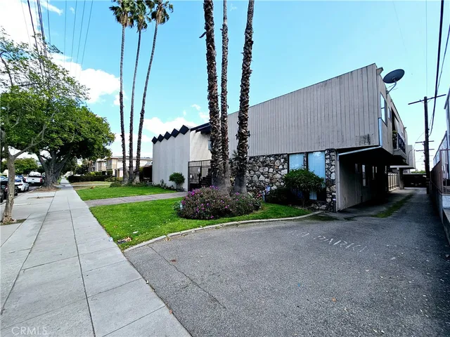 a front view of a house with garden and trees