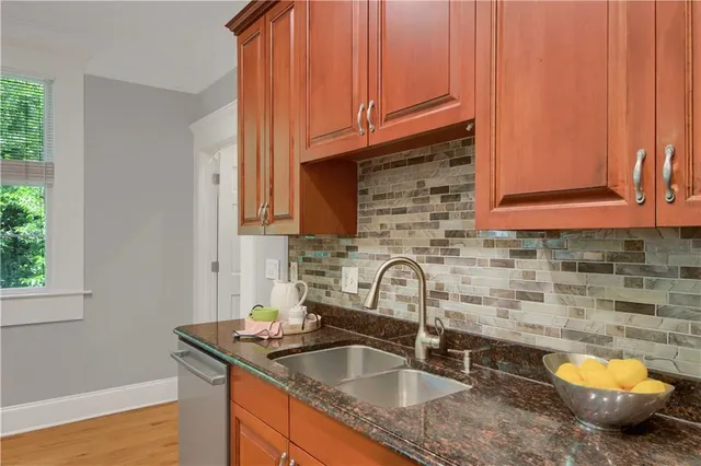 a kitchen with granite countertop a sink and a wooden cabinets