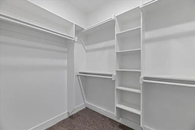 en empty room with chandelier fan and windows