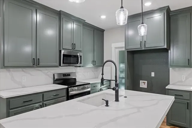 a kitchen with stainless steel appliances a sink stove and refrigerator