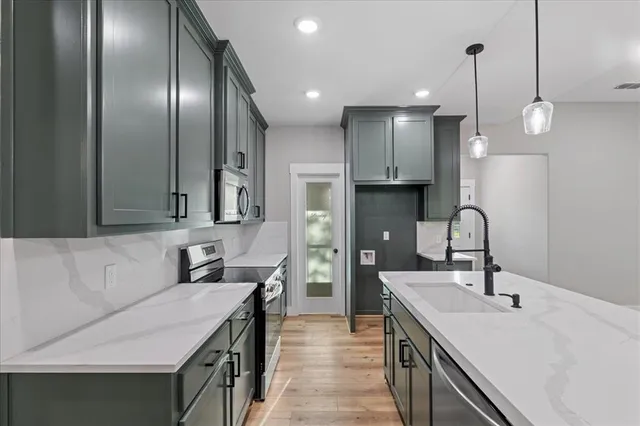 a kitchen with stainless steel appliances granite countertop a stove and a microwave
