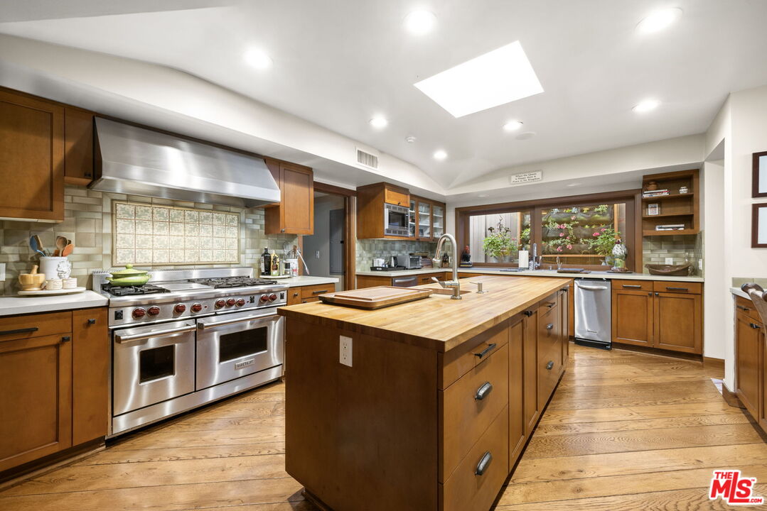 2618 Mandeville Canyon Road Los Angeles, CA 90049 - Photo 12 of 45 a kitchen with stainless steel appliances granite countertop a stove and a sink