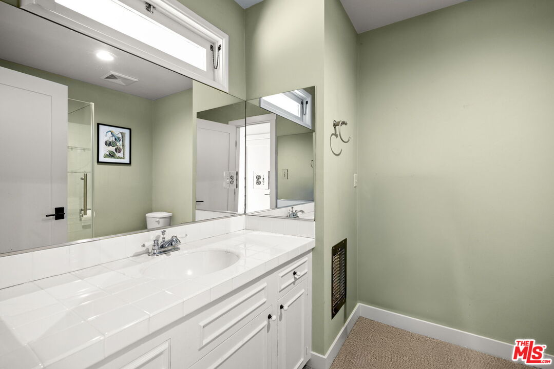 2618 Mandeville Canyon Road Los Angeles, CA 90049 - Photo 27 of 45 a bathroom with a sink and a mirror
