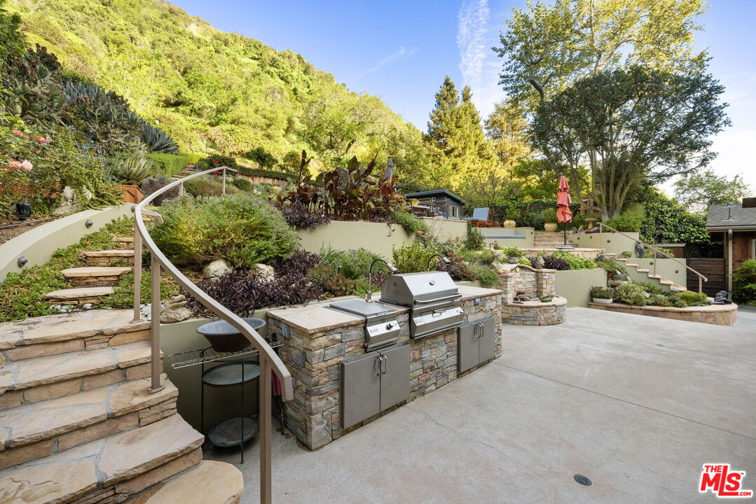 2618 Mandeville Canyon Road Los Angeles, CA 90049 - Photo 30 of 45 a view of a patio with table and chairs and potted plants