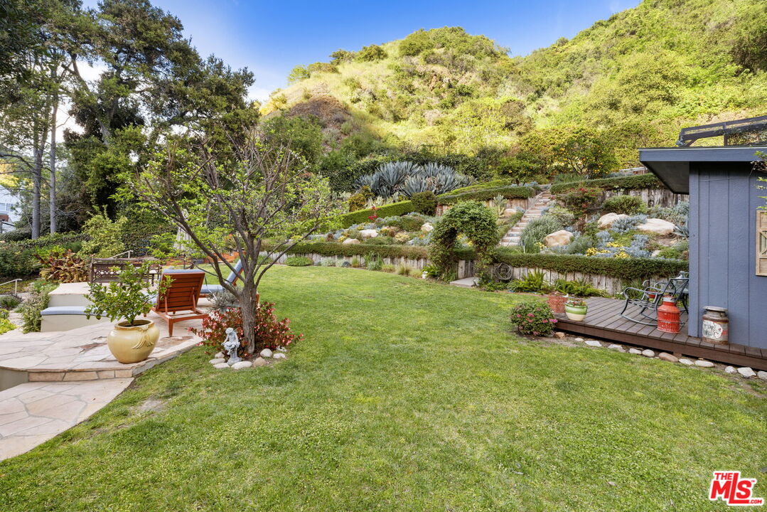 2618 Mandeville Canyon Road Los Angeles, CA 90049 - Photo 36 of 45 a view of a garden with a bench