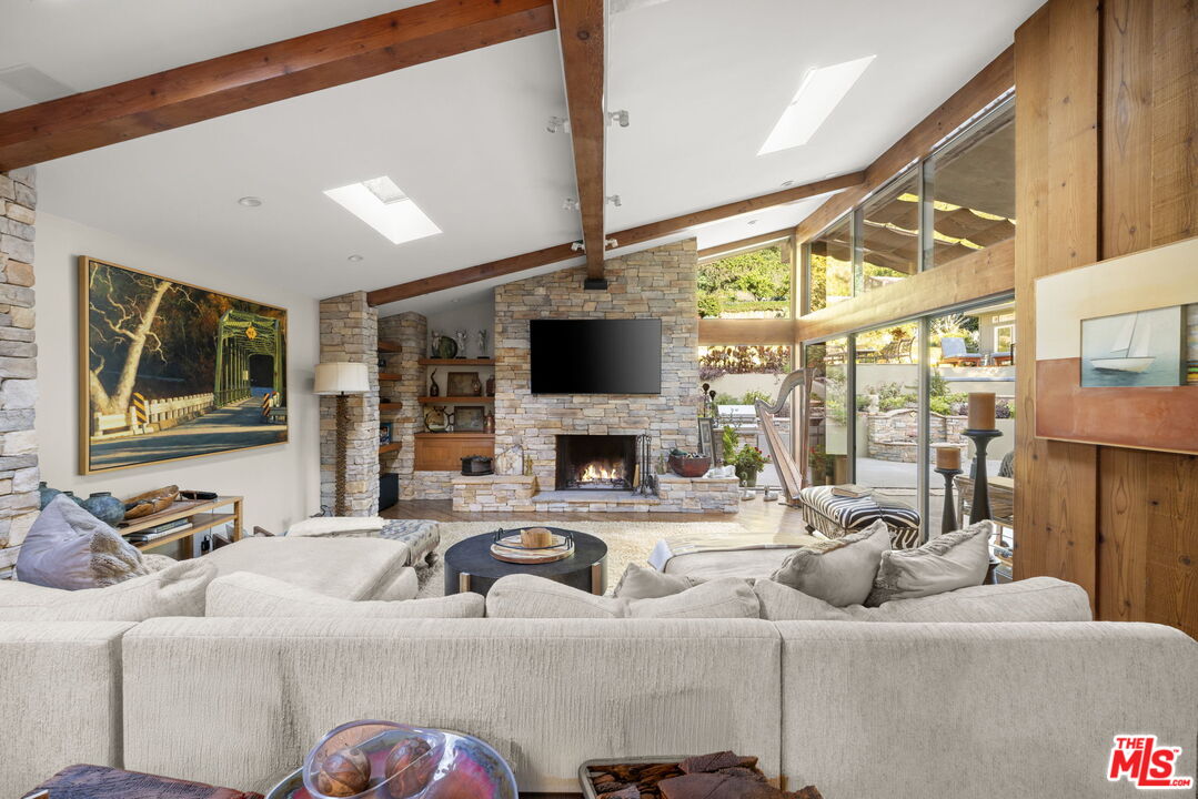 2618 Mandeville Canyon Road Los Angeles, CA 90049 - Photo 6 of 45 a living room with furniture a large window with kitchen view
