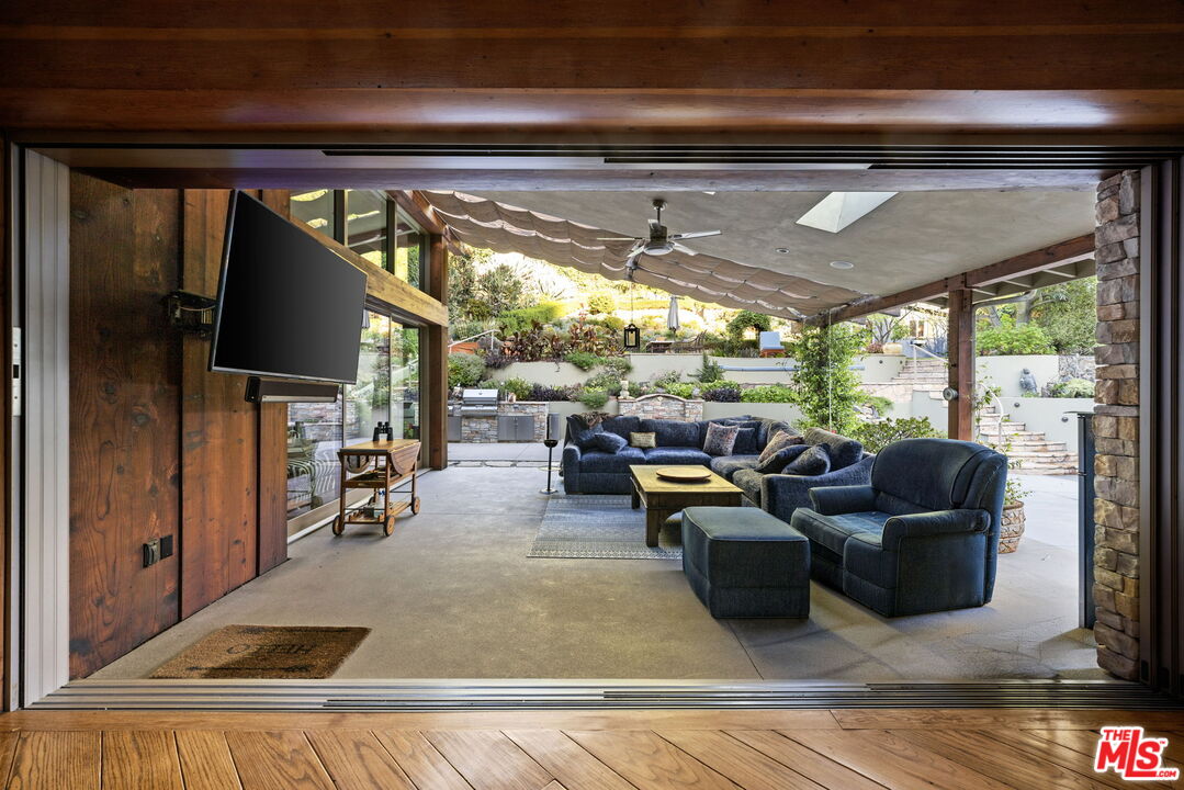 2618 Mandeville Canyon Road Los Angeles, CA 90049 - Photo 10 of 45 a living room with furniture and a flat screen tv