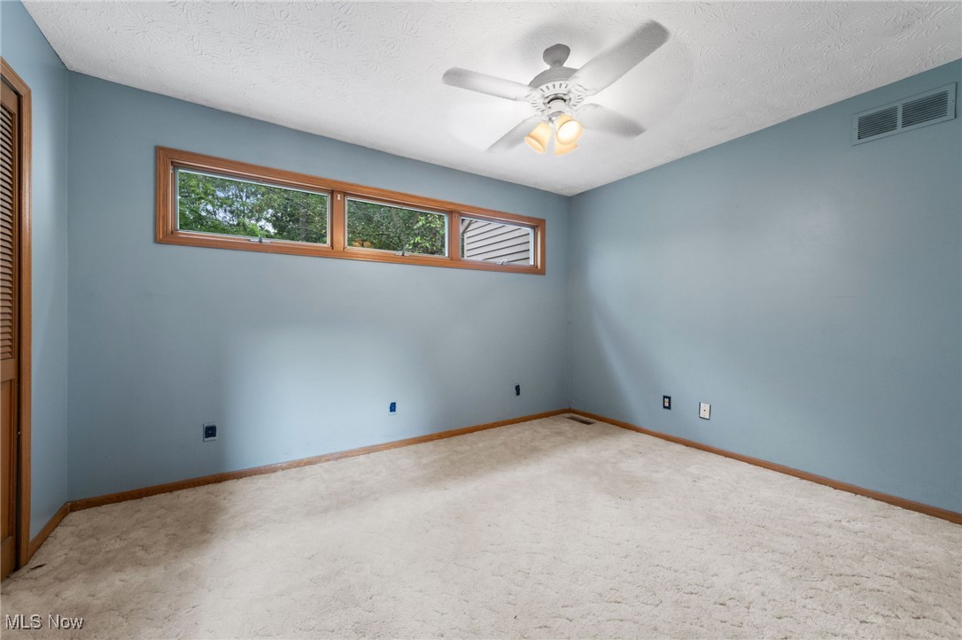 163 Burns Road Elyria, OH 44035 - Photo 19 of 37 Unfurnished bedroom featuring carpet floors, a closet, and a ceiling fan
