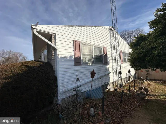 a view of house with yard and sitting area