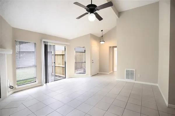 a view of a livingroom with a chandelier fan and windows