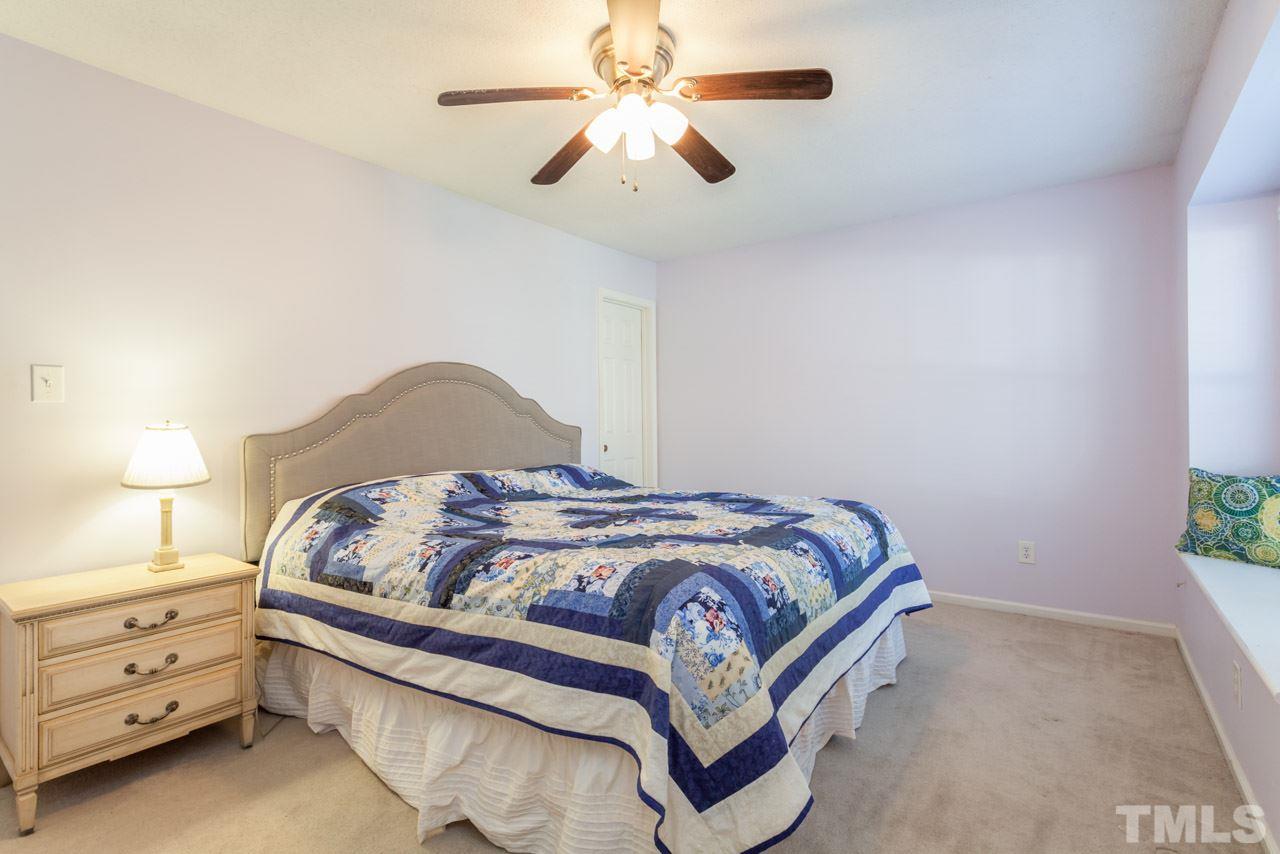 5754 Pool Side Drive Raleigh, NC 27612 - Photo 15 of 23 a bedroom with a bed and a chandelier