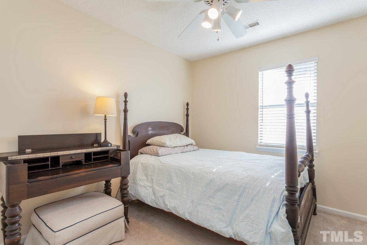 5754 Pool Side Drive Raleigh, NC 27612 - Photo 17 of 23 a bedroom with a bed and a chandelier