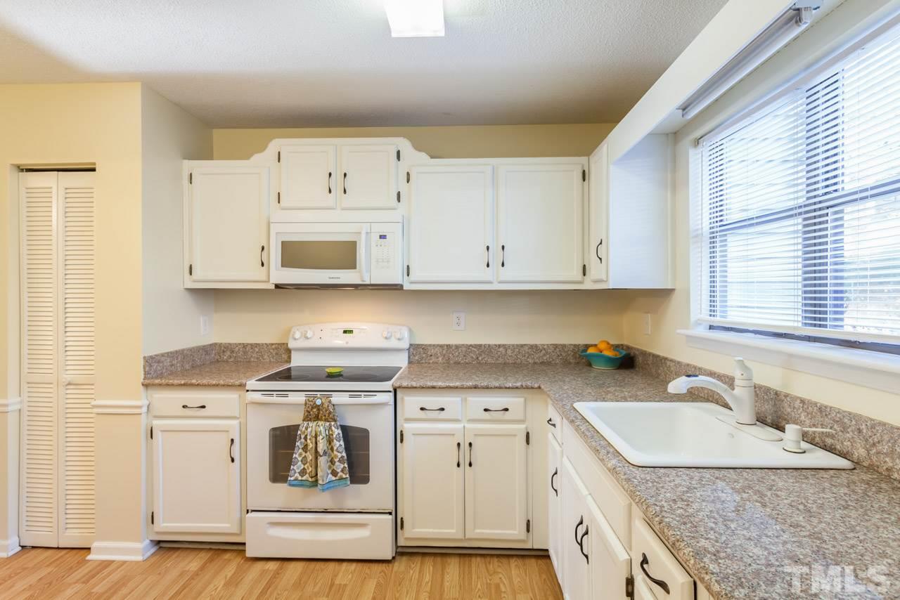 5754 Pool Side Drive Raleigh, NC 27612 - Photo 4 of 23 a kitchen with granite countertop a sink a stove and cabinets
