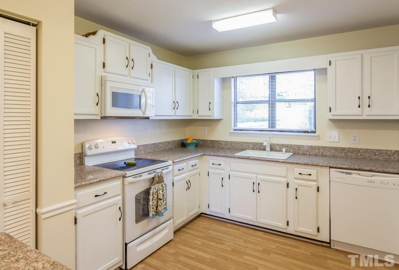 5754 Pool Side Drive Raleigh, NC 27612 - Photo 5 of 23 a kitchen with stainless steel appliances granite countertop white cabinets sink and window