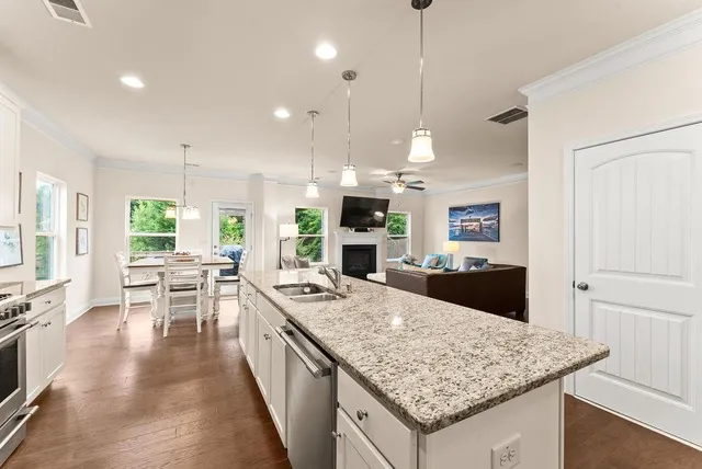 a kitchen with stainless steel appliances granite countertop a sink stove and cabinets