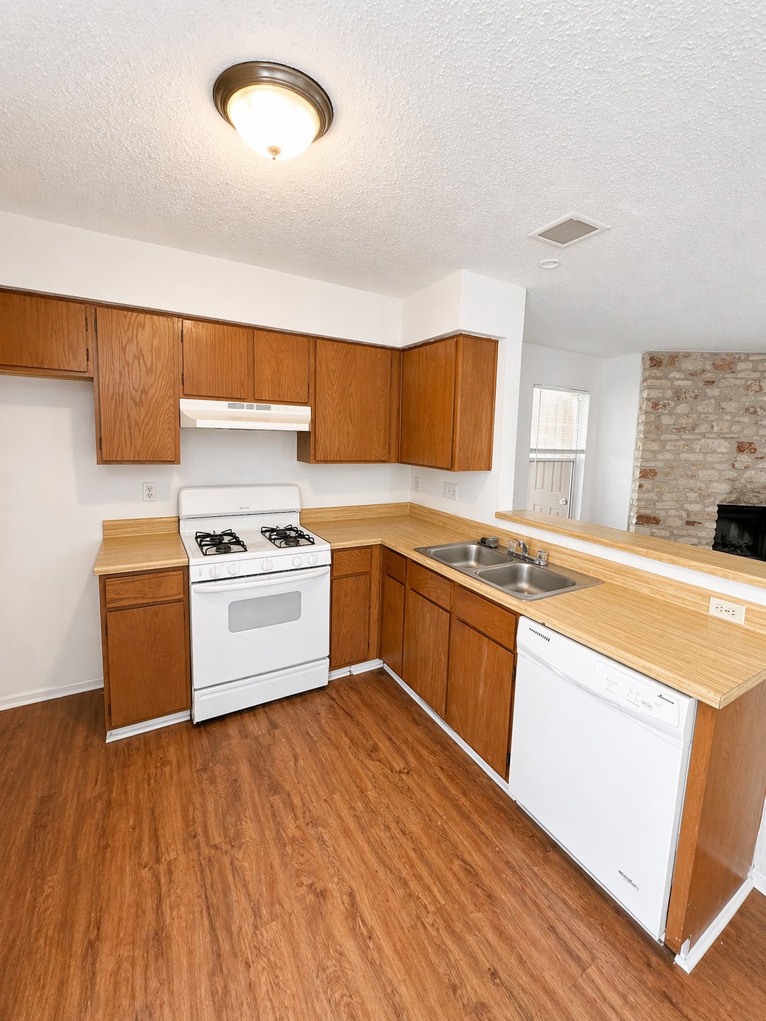 2307 Rachael Court, Unit D Austin, TX 78748 - Photo 3 of 7 a kitchen with granite countertop wooden floors and white stainless steel appliances