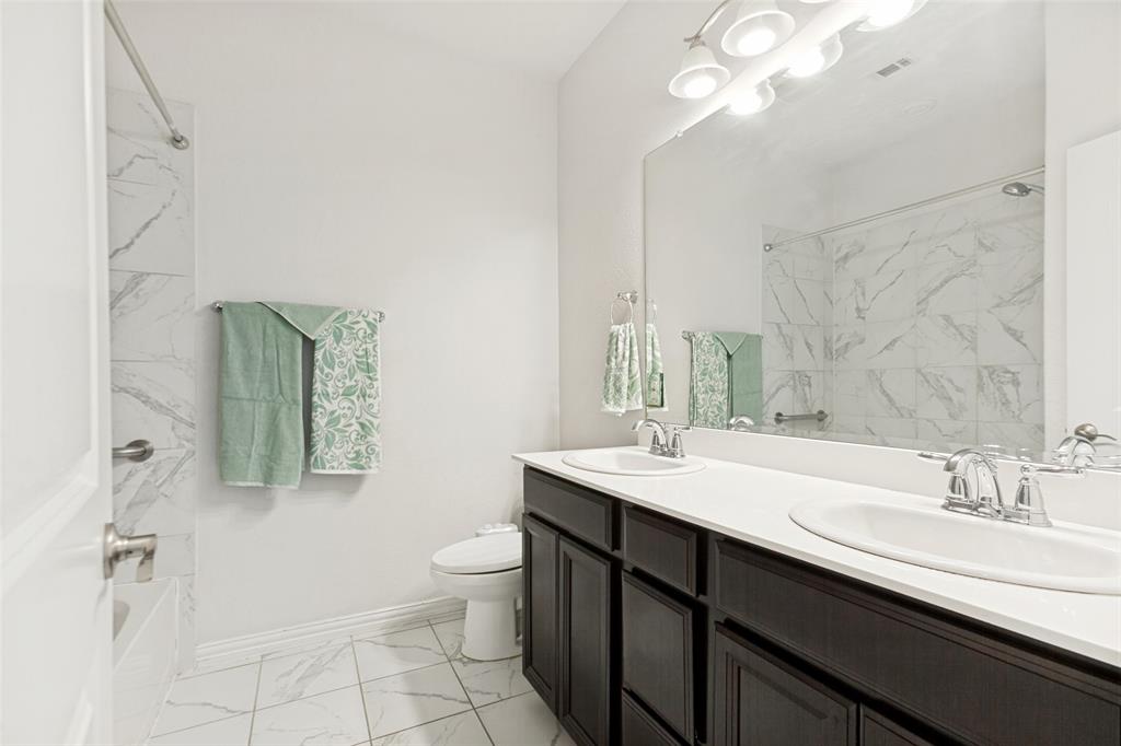 605 Ansley Way Allen, TX 75013 - Photo 21 of 28 Dual sink vanity with dark wood-finish cabinetry, white countertops, and chrome fixtures
