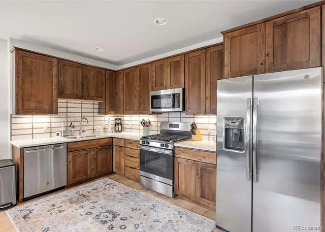 a kitchen with granite countertop stainless steel appliances cabinets a sink and a window