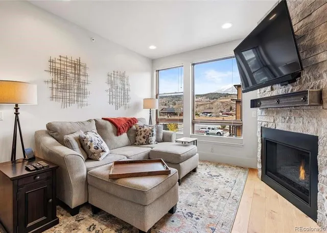 a living room with furniture a flat screen tv and a fireplace