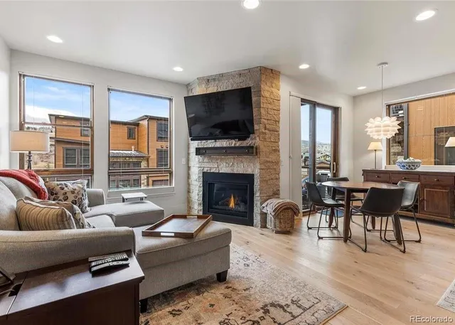 a living room with furniture a flat screen tv and a fireplace